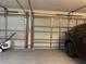 Spacious garage with room for two cars featuring a black car and lawn equipment at 11513 Andy Dr, Riverview, FL 33569