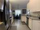 Modern kitchen with white cabinetry, stainless steel appliances, and a dining area with a round table in the background at 11513 Andy Dr, Riverview, FL 33569