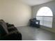 Comfortable living room setup with plush seating, a piano, and a large arched window for ample natural light at 11513 Andy Dr, Riverview, FL 33569