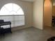 Relaxing living area featuring neutral walls, tile flooring, a piano, and a large window for natural light at 11513 Andy Dr, Riverview, FL 33569