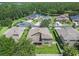 Aerial view of home with lush backyard with mature trees and a lake in the distance at 1342 Salmonberry St, Wesley Chapel, FL 33543