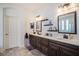 Elegant bathroom features dual sinks with dark wood cabinets and a marble countertop, plus stylish lighting at 1342 Salmonberry St, Wesley Chapel, FL 33543