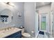 Stylish bathroom with a blue vanity, round mirror and a walk-in shower at 1342 Salmonberry St, Wesley Chapel, FL 33543