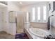 Bright bathroom with a garden tub, frameless shower, and large windows allowing natural light at 1342 Salmonberry St, Wesley Chapel, FL 33543