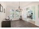 Dining room with hardwood floors, white trim, modern chandelier, and views of the front yard at 1342 Salmonberry St, Wesley Chapel, FL 33543