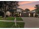 Dusk view of a well-maintained single-story home with three-car garage and manicured lawn at 1342 Salmonberry St, Wesley Chapel, FL 33543