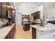 Modern kitchen with dark wood cabinets, marble countertops, stainless steel appliances and an island at 1342 Salmonberry St, Wesley Chapel, FL 33543