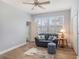 Cozy living room featuring a comfortable blue loveseat and wood-look flooring at 1342 Salmonberry St, Wesley Chapel, FL 33543