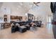 Open-concept living room featuring high ceilings, tile floors, and a large sectional sofa at 1342 Salmonberry St, Wesley Chapel, FL 33543
