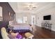 This bedroom features a tray ceiling, wood floors, and an adjacent seating area for relaxing at 1342 Salmonberry St, Wesley Chapel, FL 33543