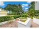 Professionally landscaped backyard with flowering plants, mature trees, and a brick patio at 1400 Cherry Ne St, St Petersburg, FL 33704