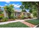 Charming home with vibrant landscaping, a brick pathway, and a welcoming porch with elegant columns at 1400 Cherry Ne St, St Petersburg, FL 33704
