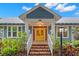 Inviting entrance featuring brick steps, white railings, and a vibrant yellow front door at 1400 Cherry Ne St, St Petersburg, FL 33704