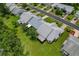 Beautiful aerial view of the home with a green yard and a glimpse of the surrounding neighborhood at 1401 Camelot Ct, Palm Harbor, FL 34684