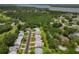 An aerial view showcasing a home in a lush community with scenic views of trees and a nearby lake at 1401 Camelot Ct, Palm Harbor, FL 34684
