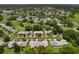 Aerial view of a home nestled in a community with mature trees, green lawns, and nearby golf courses at 1401 Camelot Ct, Palm Harbor, FL 34684