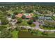 Stunning aerial view of the community clubhouse, pool, golf course and surrounding lush greenery at 1401 Camelot Ct, Palm Harbor, FL 34684