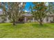 Expansive backyard with mature landscaping and a screened-in lanai at 1401 Camelot Ct, Palm Harbor, FL 34684