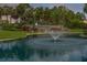 Scenic community entrance with a Highland Lakes sign, mature trees, and a tranquil fountain at 1401 Camelot Ct, Palm Harbor, FL 34684