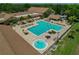 Aerial view of the community pool, hot tub, sun loungers, and clubhouse at 1401 Camelot Ct, Palm Harbor, FL 34684