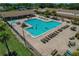 Aerial shot of the large community pool with ample lounge seating and lush landscaping at 1401 Camelot Ct, Palm Harbor, FL 34684