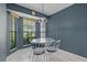 Charming dining nook with a round glass table and four chairs, bathed in natural light from nearby windows at 1401 Camelot Ct, Palm Harbor, FL 34684