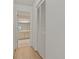 Hallway leading to bathroom with hardwood floors and featuring closet storage at 1401 Camelot Ct, Palm Harbor, FL 34684