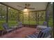 The screened in patio has tile floor, ceiling fan, and seating area at 1401 Camelot Ct, Palm Harbor, FL 34684
