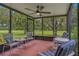 Screened lanai with tile flooring, ceiling fan, and views of the lush lawn at 1401 Camelot Ct, Palm Harbor, FL 34684