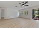 Spacious room with neutral palette, shutters, ceiling fan, and sliding doors to patio at 1401 Camelot Ct, Palm Harbor, FL 34684