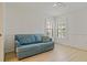 Bright living room with a comfortable blue sofa, complemented by light wood floors and shuttered windows at 1401 Camelot Ct, Palm Harbor, FL 34684