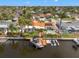 Aerial view of a waterfront property with a private pool, dock, and boat lift surrounded by lush landscaping and neighboring homes at 1424 47Th Ne Ave, St Petersburg, FL 33703