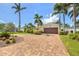 Charming one-story home featuring lush landscaping, a brick driveway, and mature palm trees at 1424 47Th Ne Ave, St Petersburg, FL 33703