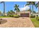 Attractive single-story home with lush landscaping, a brick driveway, and an attached two-car garage at 1424 47Th Ne Ave, St Petersburg, FL 33703
