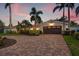 Inviting single-story home with a brick driveway, lush landscaping, and a well-maintained lawn at 1424 47Th Ne Ave, St Petersburg, FL 33703