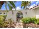 Stylish home entrance with an arched doorway, stucco walls, and tropical landscaping at 1424 47Th Ne Ave, St Petersburg, FL 33703