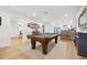 Large game room with pool table, hardwood floors, and views of the kitchen and dining area at 1424 47Th Ne Ave, St Petersburg, FL 33703