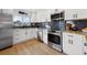 Modern kitchen boasts stainless steel appliances, white cabinets, and a stylish backsplash at 1424 47Th Ne Ave, St Petersburg, FL 33703