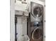 Efficient laundry area featuring stacked washer and dryer and storage shelves at 1424 47Th Ne Ave, St Petersburg, FL 33703