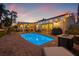 Outdoor pool area with brick pavers, grill, fire pit and patio seating under the lights at 1424 47Th Ne Ave, St Petersburg, FL 33703