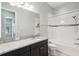Bright bathroom with granite countertop, undermount sink, and tiled shower and tub with accent tiles at 1902 Marshberry Ct, New Port Richey, FL 34655