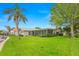 The backyard of the property features lush landscaping, a screened in porch, and mature trees at 1917 Iowa Ne Ave, St Petersburg, FL 33703