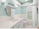 Bright bathroom featuring a white vanity with stone countertops and a large round mirror at 1917 Iowa Ne Ave, St Petersburg, FL 33703