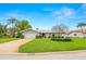 Inviting home with lush green lawn, mature trees, and attractive landscaping, and a two car garage at 1917 Iowa Ne Ave, St Petersburg, FL 33703