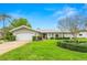Charming single-story home with lush front lawn, mature trees, and well-maintained landscaping at 1917 Iowa Ne Ave, St Petersburg, FL 33703