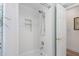 Clean white shower with a built-in shelf and handheld shower head in updated bathroom at 1917 Iowa Ne Ave, St Petersburg, FL 33703