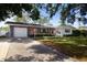 Inviting brick home featuring a well-maintained lawn, attached garage, and a welcoming entrance at 2010 6Th Sw Ave, Largo, FL 33770