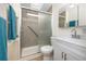 Bathroom with a shower, glass door, and grab bar, plus a vanity with a white cabinet at 2011 Ketch Cir, Palm Harbor, FL 34683