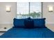 Bedroom features a blue bedspread, window with blinds, and bedside table at 2011 Ketch Cir, Palm Harbor, FL 34683