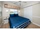 Bedroom features a blue bedspread, built-in cabinets above the window, and a ceiling fan at 2011 Ketch Cir, Palm Harbor, FL 34683